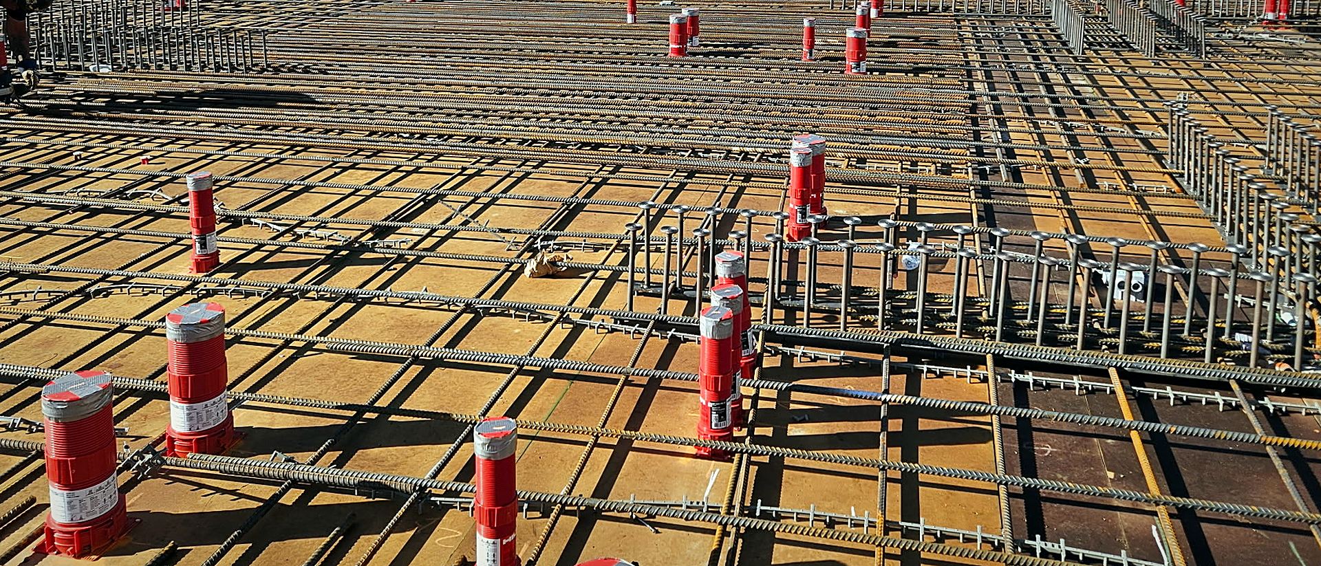 A tied reinforcing steel mat running the full slab, chairs and dowels set, ready for the pour