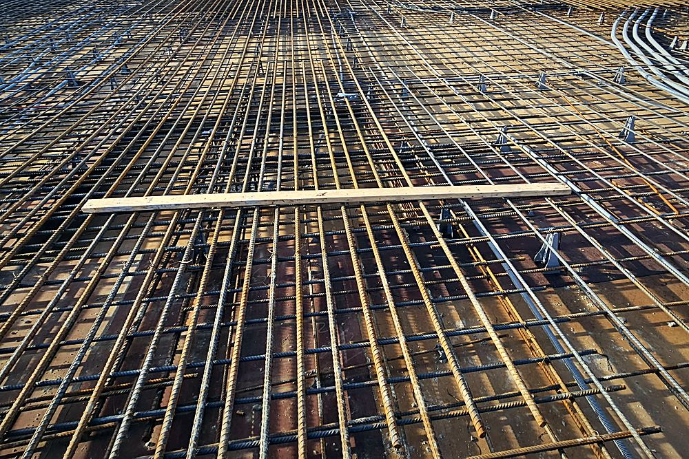 A slab tied out end to end, conduit run and chaired ready for concrete