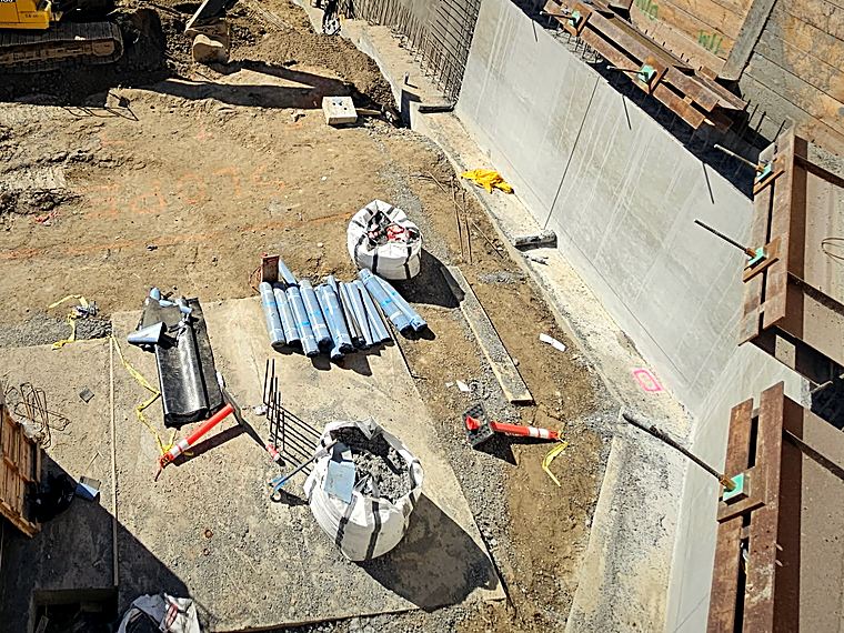 Shored excavation with poured foundation walls and dowels left for the next lift