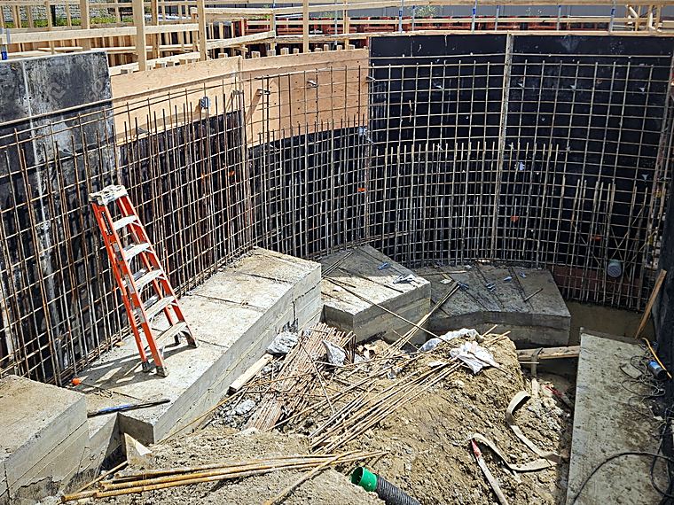 Curved foundation wall reinforcing set into formwork on a footing